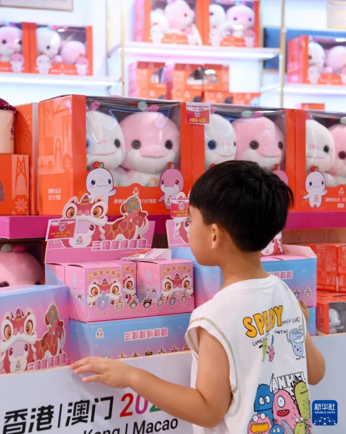 7月14日，又名男孩在香港西九龙站官方零卖店浏览。当日，第十五届寰宇默契会香港赛区官方特准商品启动发售。新华社记者 陈铎 摄